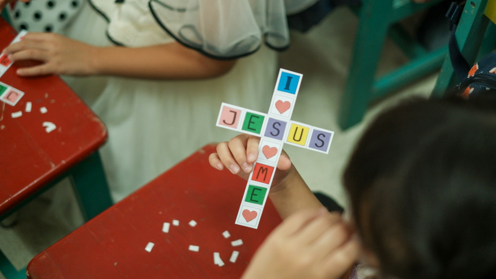 Child creating an "I Love Jesus" artwork